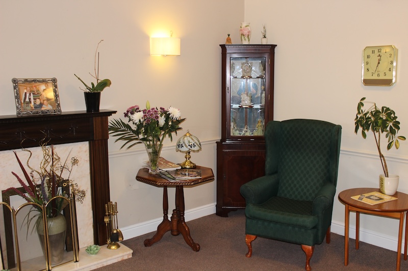armchair sat next to the ornament cabinet